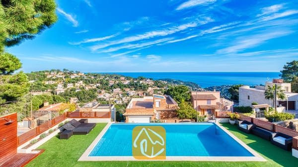Privézwembad bij Villa Chanel met kunstgras, zwarte loungeset en een panoramisch uitzicht over de Middellandse Zee en het kustplaatsje.